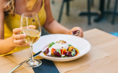 Person dining outdoors - Image by bodiaphvideo / Shutterstock.com